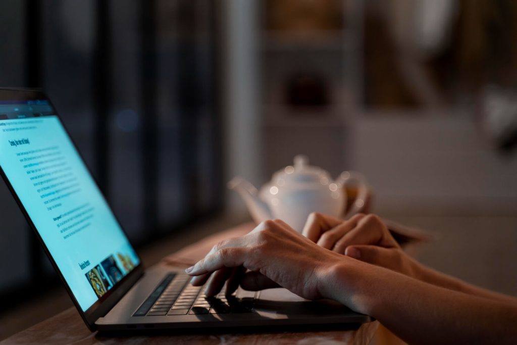 A person creating blog on laptop content for seasonal and local travel trends